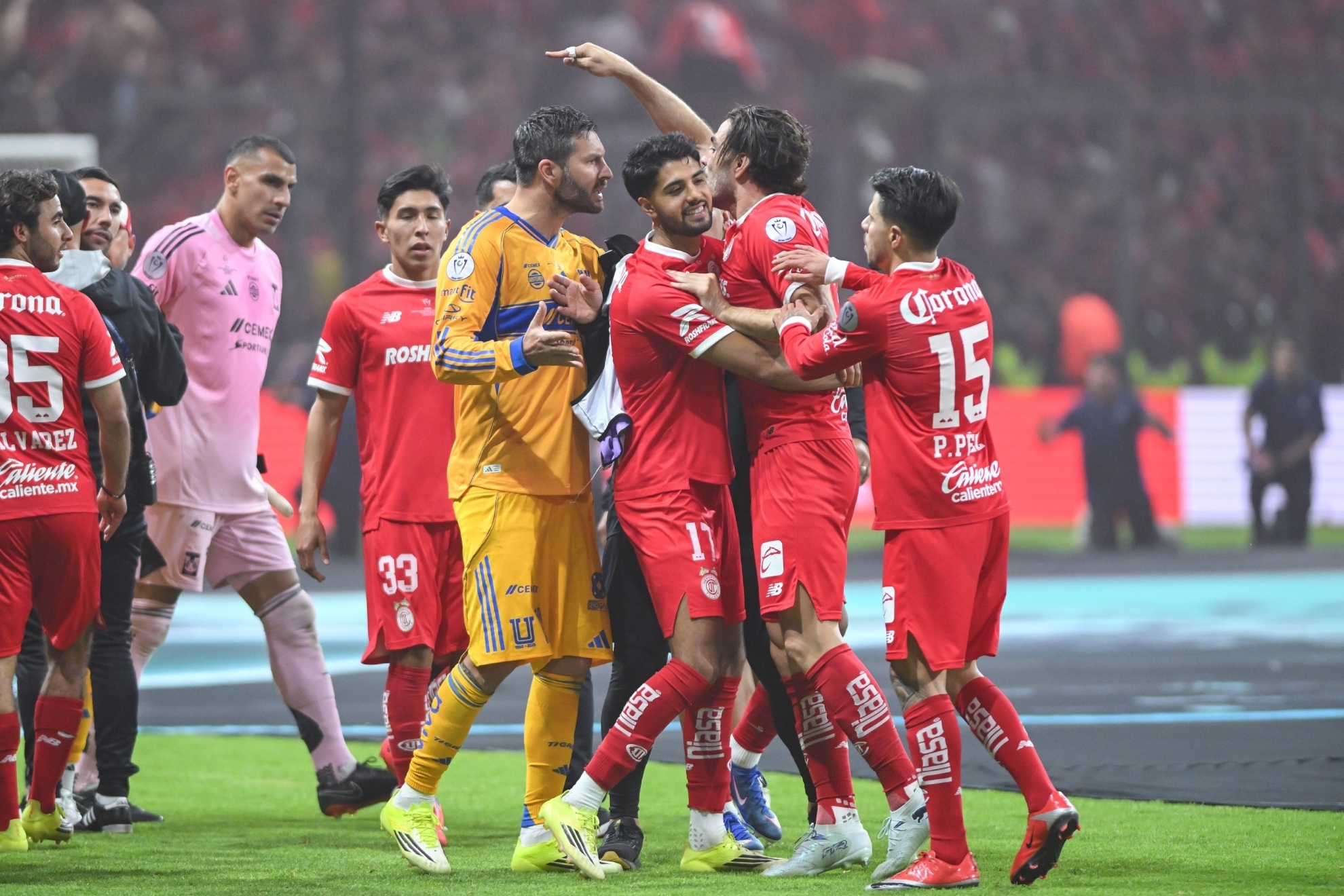 Compañeros del Pollo Briseño y Gignac tratan de frenar al jugador de Toluca. MEXSPORT