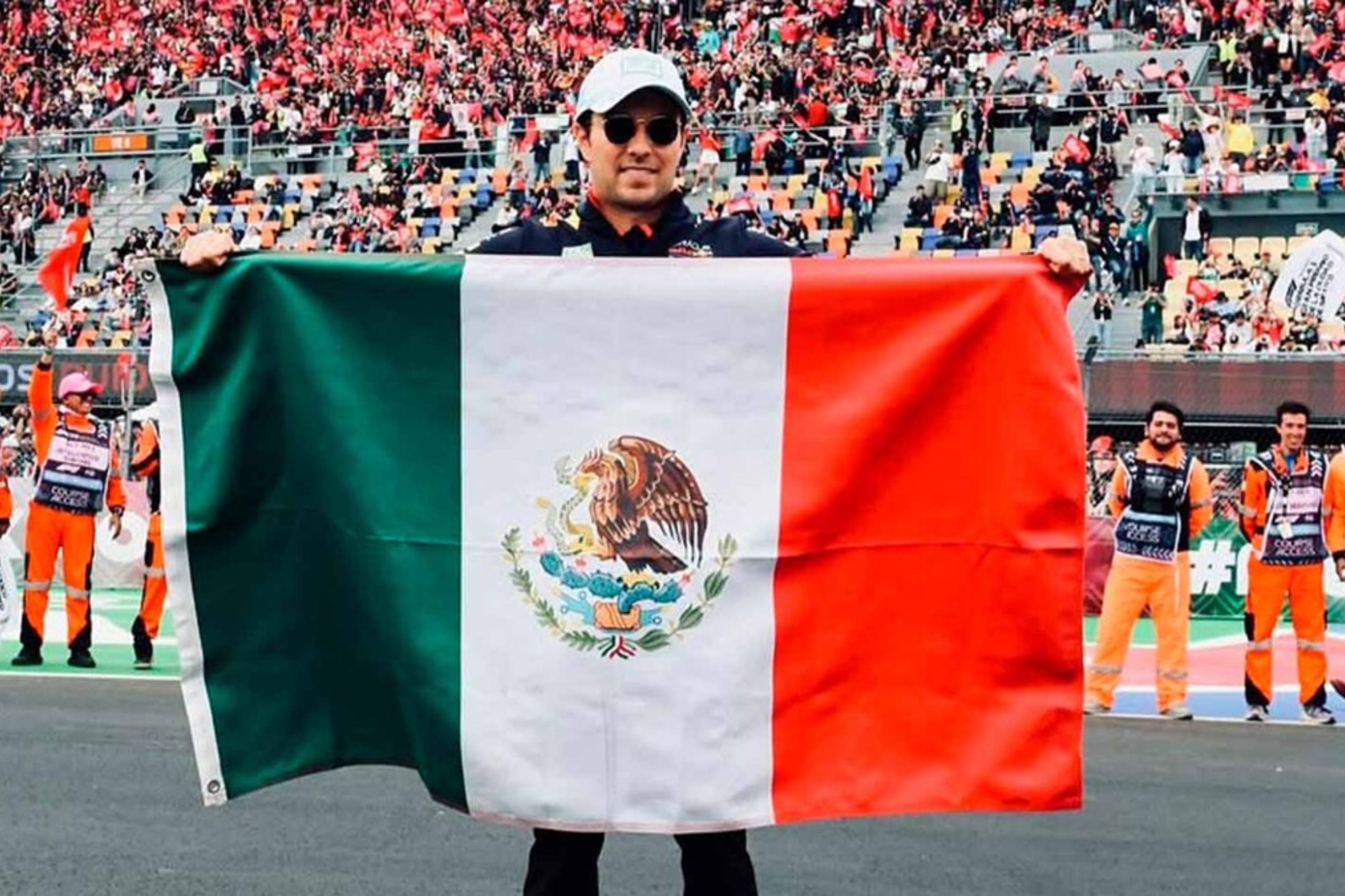 Checo posa con la bandera de México durante su etapa en Red Bull